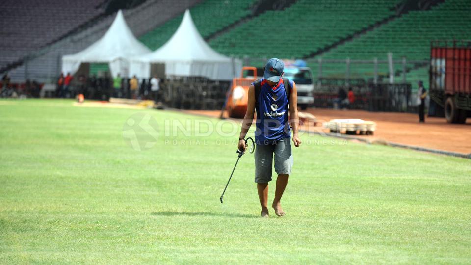 Petugas melakukan pemotongan rumput.